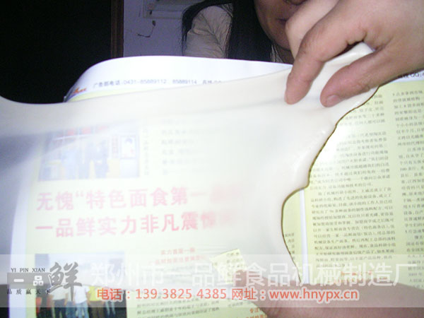 燴面機(jī)HMJ-5型(適合城市大規(guī)模批發(fā))(圖6) 透過一品鮮燴面坯看報(bào)紙